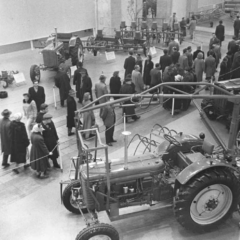 Besucher der Frühjahrsmesse betrachten verschiedene Exponate, hier Maschinen der Landwirtschaft. In der Halle sind mehrere Traktoren zu sehen. Im Frühjahr und im Herbst eines jeden Jahres war die Leipziger Messe Treffpunkt der internationalen Handelswelt. Bestmögliche Qualität nach Vorlage!