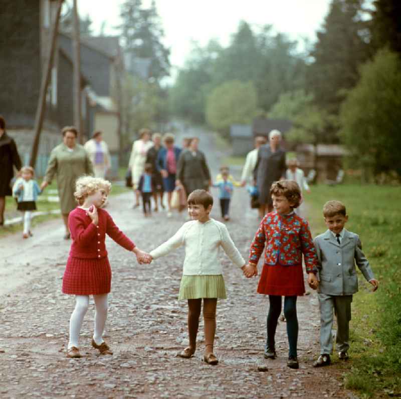 Kinder und Frauen gehen in Masserberg im Thüringer Wald spazieren, zum Pfingstfest tragen sie festliche Kleidung. Der Thüringer Wald mit seinen Wander- und Erholungsmöglichkeiten war ein beliebtes Ausflugs- und Urlaubsziel in der DDR.