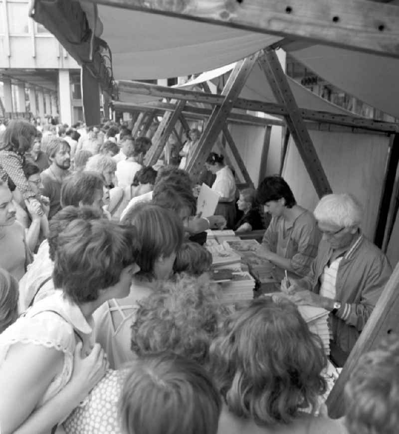 Der Schriftsteller Benno Pludra (r.) an seinem Büchertisch mit Besuchern auf dem Schriftstellerbasar in Potsdam.