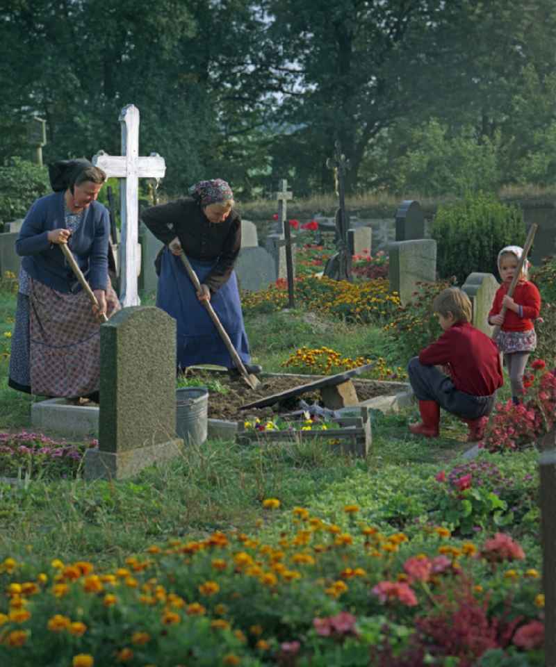 Scene from the film and television production ' Portrait of a Center ' in front of grave crosses and cemetery stones of a Sorbian cemetery on the main street in Ralbitz, Saxony in the area of the former GDR, German Democratic Republic