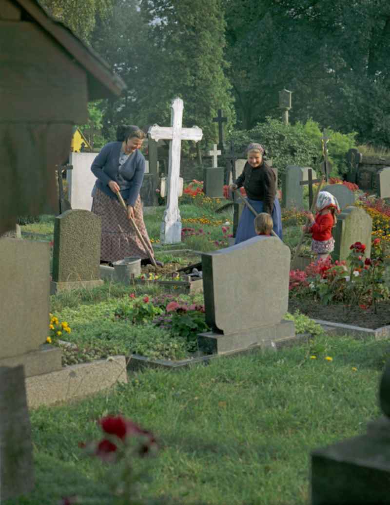 Scene from the film and television production ' Portrait of a Center ' in front of grave crosses and cemetery stones of a Sorbian cemetery on the main street in Ralbitz, Saxony in the area of the former GDR, German Democratic Republic