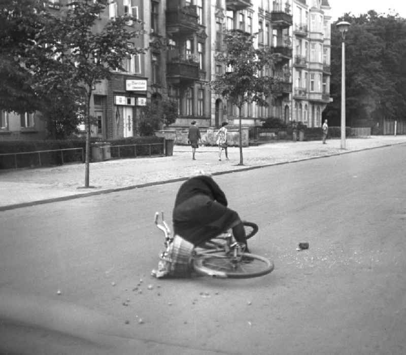 Eine alte Frau stürzt mit ihrem Fahrrad auf einer Straße in Rostock. Der Einkaufsbeutel am Lenkrad hatte sich in den Speichen verfangen.