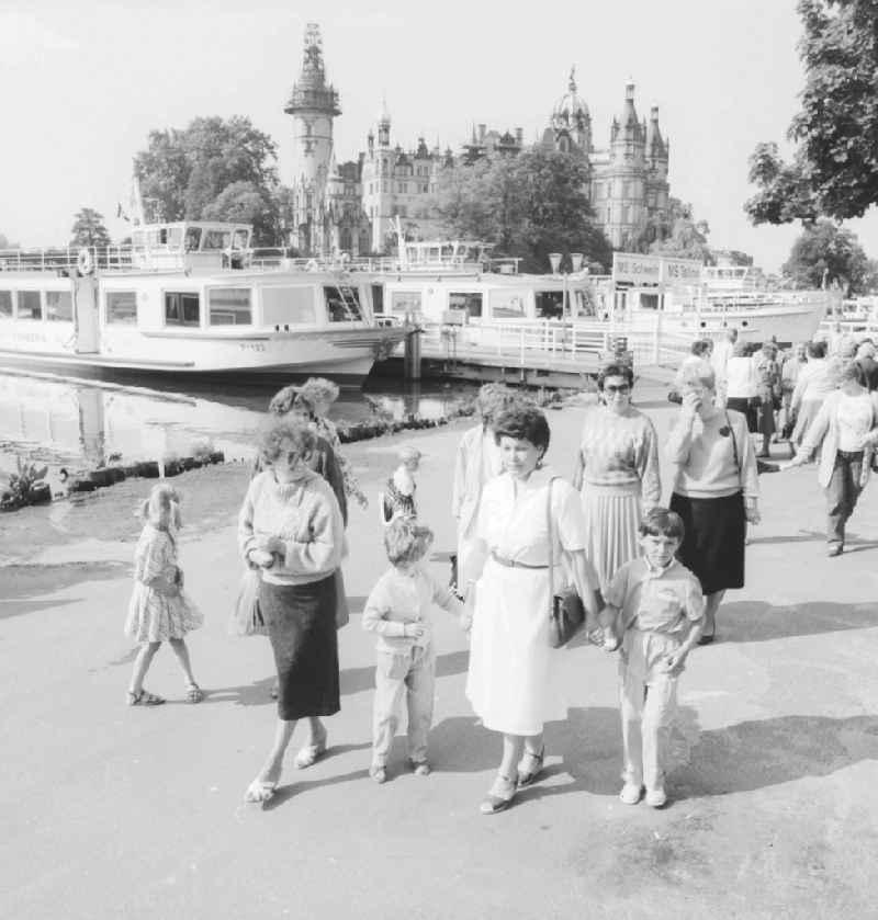 Guests and tourists in the steamboat landing stage of the 'Weissen Flotte' in the Schweriner lake in Schwerin in the federal state Mecklenburg-West Pomerania in the area of the former GDR, German democratic republic