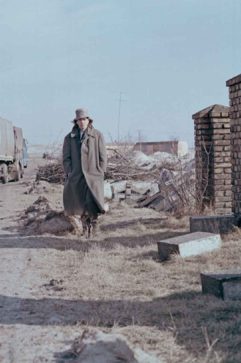 Scene from the film and television production Rublak - The Legend of the Surveyed Land Waste landscape in Lusatia - the actor Christian Grashof walks past the destroyed entrance of a cleared cemetery entrance on the street Scene in Spremberg in GDR