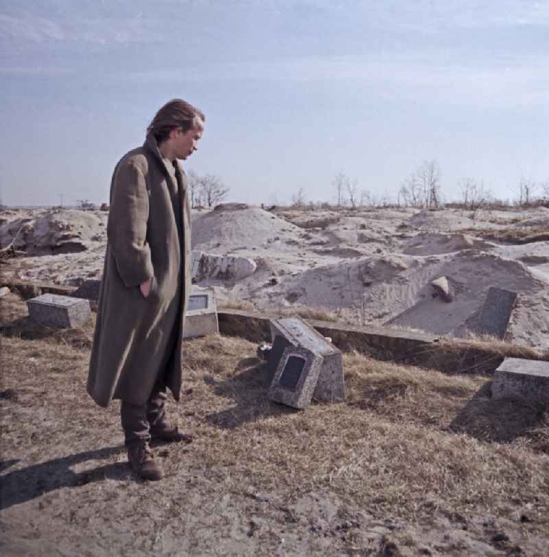 Scene from the film and television production Rublak - The Legend of the Surveyed Land Waste landscape in Lusatia - the actor Christian Grashof walks past the destroyed entrance of a cleared cemetery entrance on the street Scene in Spremberg in GDR