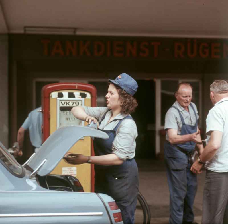 Reger Betrieb herrscht an einer Tankstelle 'Tankdienst Rügendamm' vor der beliebten Urlaubsinsel Rügen. Ein weiblicher Tankwart bedient Kunden.