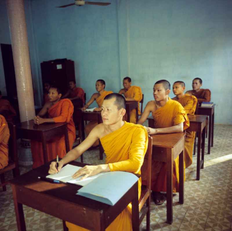 Mönche in den charakteristischen safrangelben Gewändern lernen in der Schule in einem buddhistischen Tempel in Vientiane, der Hauptstadt der Demokratischen Volksrepublik Laos. Bis zur Ausrufung der Volksrepublik Laos am 2. Dezember 1975 bestimmte der Theravada-Buddhismus die kulturelle Entwicklung im Land. Nachdem die anfängliche Unterdrückung der traditionellen buddhistischen Bräuche durch die neuen kommunistischen Machthaber mißlang, fand Laos in den folgenden Jahrzehnten einen eigenen Weg der Koexistenz von Buddhismus und Sozialismus.