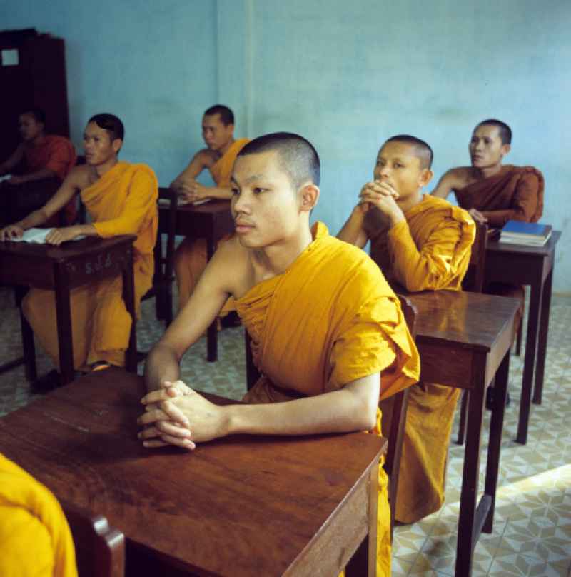 Mönche in den charakteristischen safrangelben Gewändern lernen in der Schule in einem buddhistischen Tempel in Vientiane, der Hauptstadt der Demokratischen Volksrepublik Laos. Bis zur Ausrufung der Volksrepublik Laos am 2. Dezember 1975 bestimmte der Theravada-Buddhismus die kulturelle Entwicklung im Land. Nachdem die anfängliche Unterdrückung der traditionellen buddhistischen Bräuche durch die neuen kommunistischen Machthaber mißlang, fand Laos in den folgenden Jahrzehnten einen eigenen Weg der Koexistenz von Buddhismus und Sozialismus.