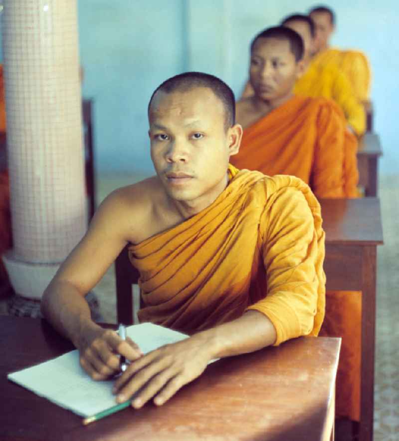 Mönche in den charakteristischen safrangelben Gewändern lernen in der Schule in einem buddhistischen Tempel in Vientiane, der Hauptstadt der Demokratischen Volksrepublik Laos. Bis zur Ausrufung der Volksrepublik Laos am 2. Dezember 1975 bestimmte der Theravada-Buddhismus die kulturelle Entwicklung im Land. Nachdem die anfängliche Unterdrückung der traditionellen buddhistischen Bräuche durch die neuen kommunistischen Machthaber mißlang, fand Laos in den folgenden Jahrzehnten einen eigenen Weg der Koexistenz von Buddhismus und Sozialismus.