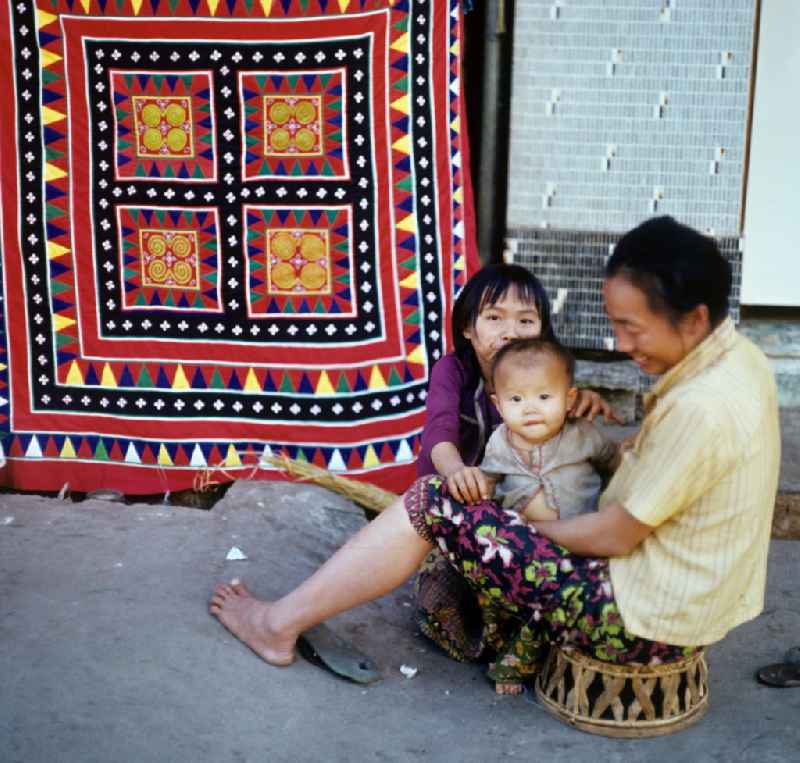 Eine Frau aus dem Volksstamm der Meo, auch Hmong genannt, verkauft selbstgenähte Decken in Vientiane, der Hauptstadt der Demokratischen Volksrepublik Laos. Die Hmong gehörten zu einer infolge des Vietnam-Krieges verfolgten und zurückgezogen lebenden Minderheit in Laos.