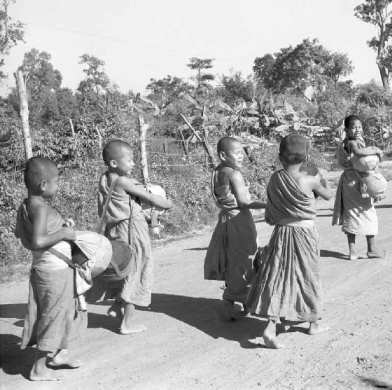 Früh am Morgen ziehen kleine Bettelmönche durch Vientiane, der Hauptstadt der Demokratischen Volksrepublik Laos, um sich Essen für den Tag zu erbetteln.