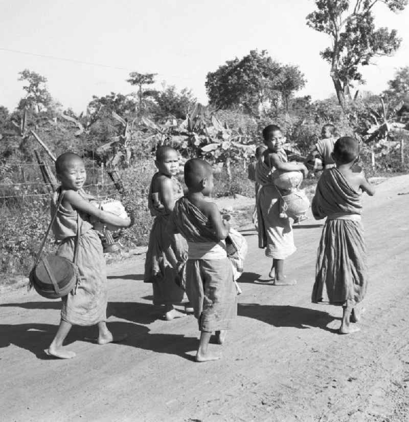 Früh am Morgen ziehen kleine Bettelmönche durch Vientiane, der Hauptstadt der Demokratischen Volksrepublik Laos, um sich Essen für den Tag zu erbetteln.