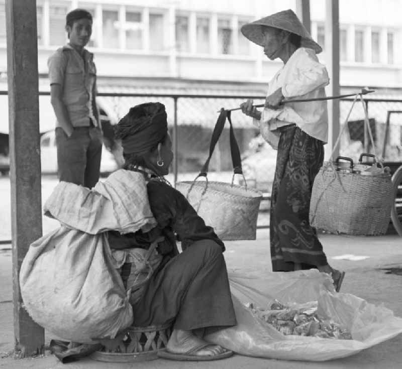Eine Frau trägt geschulterte Körbe auf dem Markt in Vientiane, der Hauptstadt der Demokratischen Volksrepublik Laos.