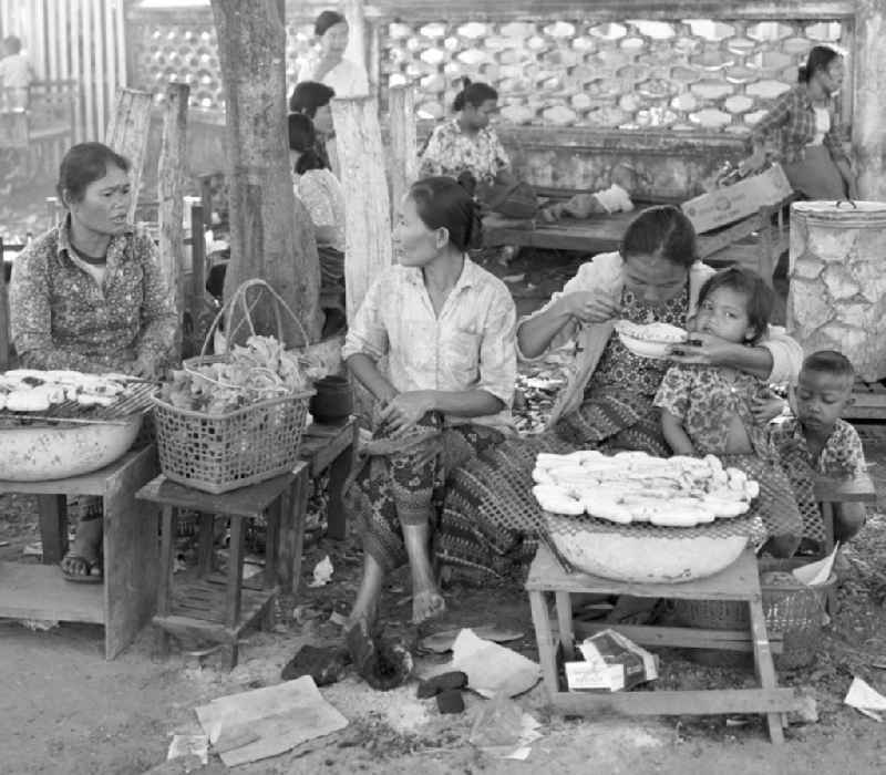 Frauen mit ihren Kindern verkaufen Lebensmittel an Marktständen in Vientiane, der Hauptstadt der Demokratischen Volksrepublik Laos.