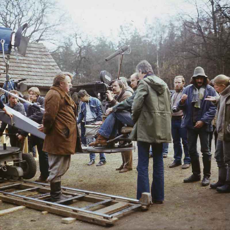 Scene from the film and television production 'Rublak - The Legend of the Surveyed Land' in Weisskeissel, Saxony in the area of the former GDR, German Democratic Republic. The cameraman Lutz Koerner is filming the actor Kurt Boewe from a crane that is standing on rails. The director Konrad Herrmann and members of the film crew are standing behind him