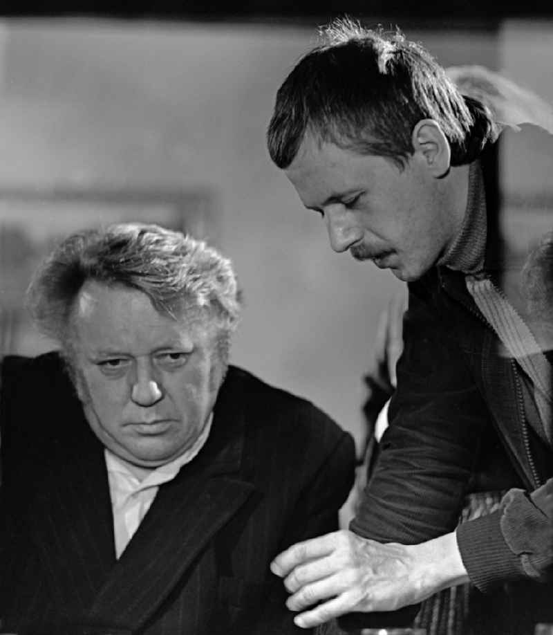 Scene from the film and television production 'Rublak - The Legend of the Surveyed Land' in the Haide district of Weisskeissel, Saxony in the area of the former GDR, German Democratic Republic. The actor Kurt Boewe sits at a table and listens attentively to the instructions given to him by the director Konrad Herrmann