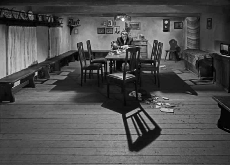 Scene from the film and television production 'Rublak - The Legend of the Surveyed Land' with the actor Kurt Boewe alone at the table in a farmhouse in the district of Haide in Weisskeissel, Saxony in the territory of the former GDR, German Democratic Republic