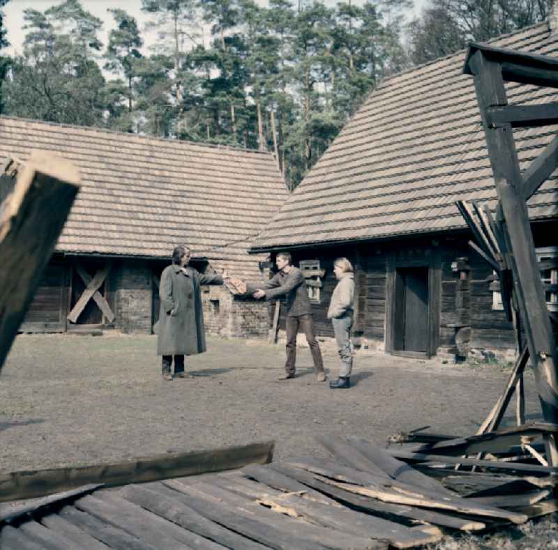 Scene from the film and television production 'Rublak - The Legend of the Surveyed Land' in the Haide district of Weisskeissel, Saxony in the area of the former GDR, German Democratic Republic. The actor Christian Grashof hands the actor Hans-Uwe Bauer a violin. The actress Johanna Schall observes the events in the courtyard of a farmhouse