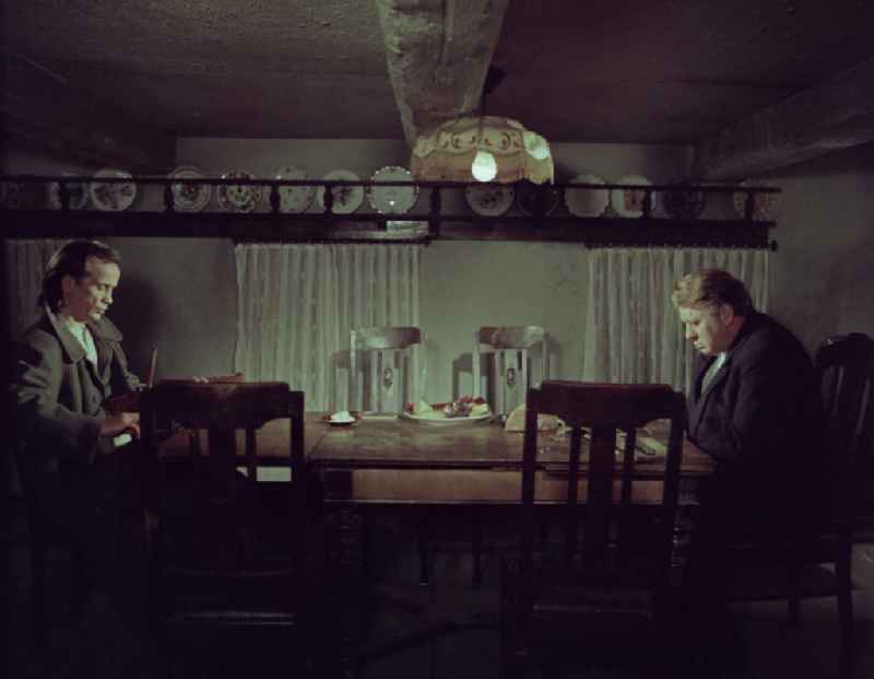 Scene from the film and television production 'Rublak - The Legend of the Surveyed Land' in the Haide district of Weisskeissel, Saxony in the area of the former GDR, German Democratic Republic. The actor Christian Grashof and the actor Kurt Boewe sit opposite each other at a table in a farmhouse parlor