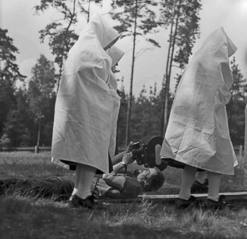 Traditional costumes and clothing of a Sorbian farmer's wife as a scene in the film 'Rublak - The Legend of the Surveyed Land' in the town of Heide, Saxony in the area of the former GDR, German Democratic Republic. The cameraman Franz Ritschel lies on the lawn and films