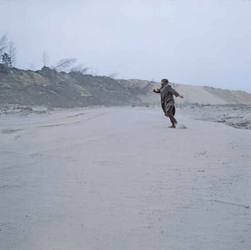 Scene from the film and television production 'Rublak - The Legend of the Surveyed Land' in Weisswasser/Oberlausitz, Saxony in the area of the former GDR, German Democratic Republic. The actor Christian Grashof dances on a large, flat sandy plain in the waste landscape of a brown coal open-cast mine