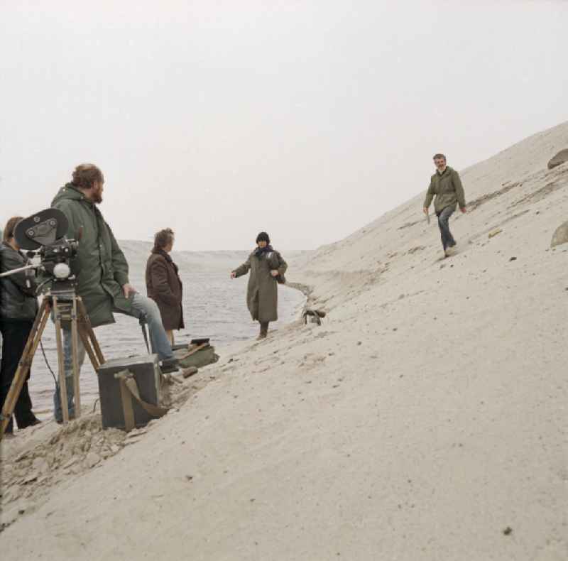 Scene from the film and television production 'Rublak - The Legend of the Surveyed Land' in Weisswasser/Oberlausitz, Saxony in the area of the former GDR, German Democratic Republic. The actor Christian Grashof walks with a violin case under his arm through the sandy plain in the waste landscape of a brown coal open-cast mine