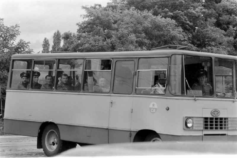 Soviet soldiers in uniform of the Red Army of the GSSD 'Group of Soviet Forces in Germany' ride in a minibus military vehicle 'Progress-3