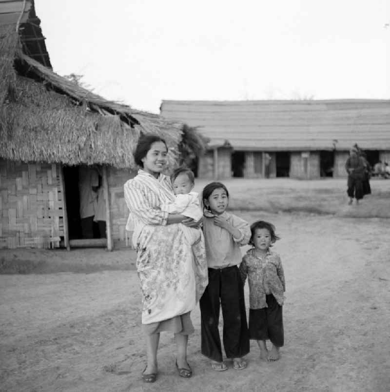 Frauen und Kinder aus dem Volksstamm der Meo (auch Hmong) vor einer Hütte an der sogenannten 'Ebene der Tonkrüge' in der Provinz Xieng Khouang in der Demokratischen Volksrepublik Laos. Die Hmong gehörten zu einer infolge des Vietnam-Krieges verfolgten und zurückgezogen lebenden Minderheit in Laos.